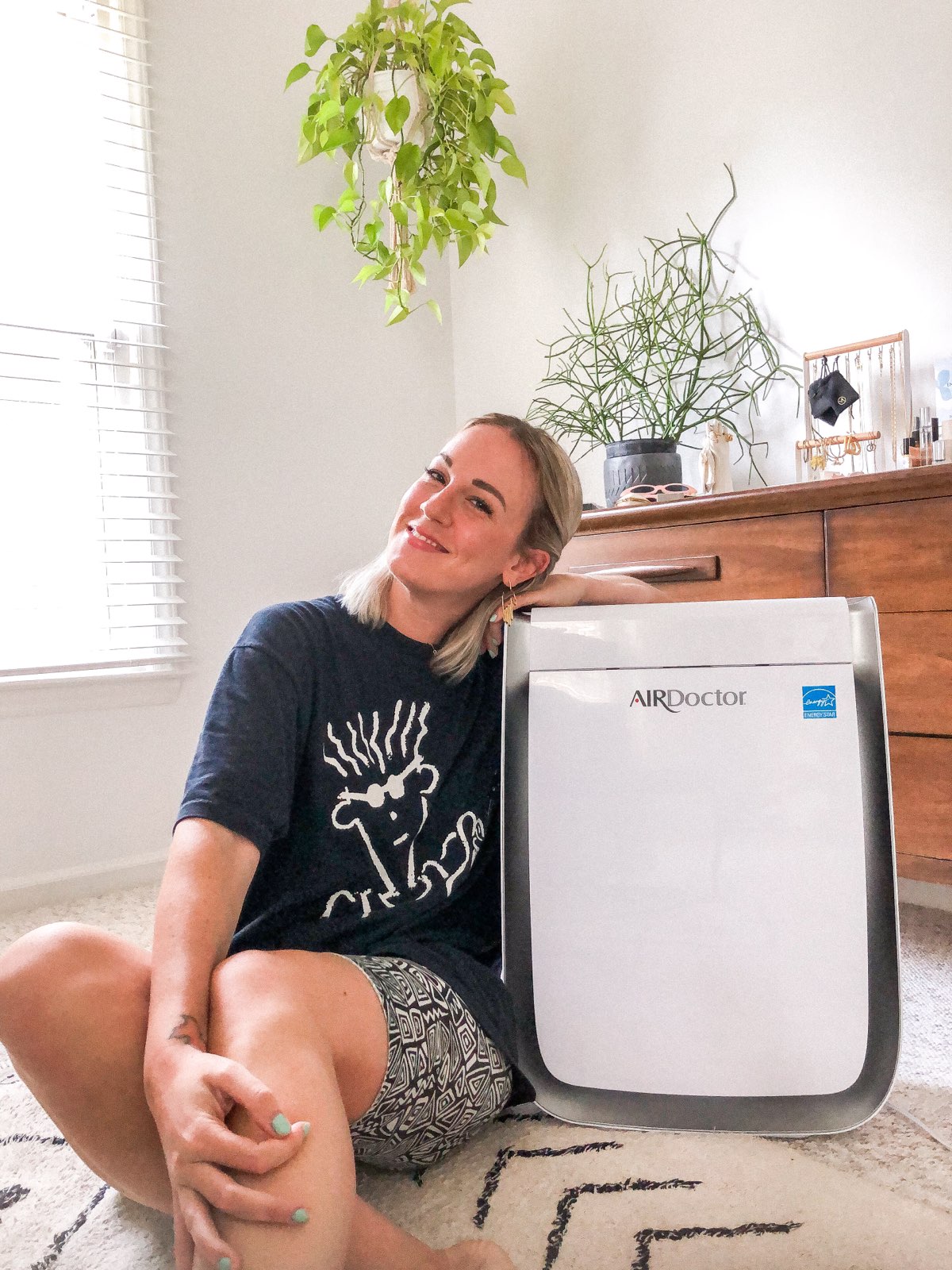 Girl sitting with an air purifier. AirDoctor Pro Air Purifier